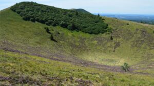 Vue aérienne d'un cratère volcanique verdoyant entouré de végétation