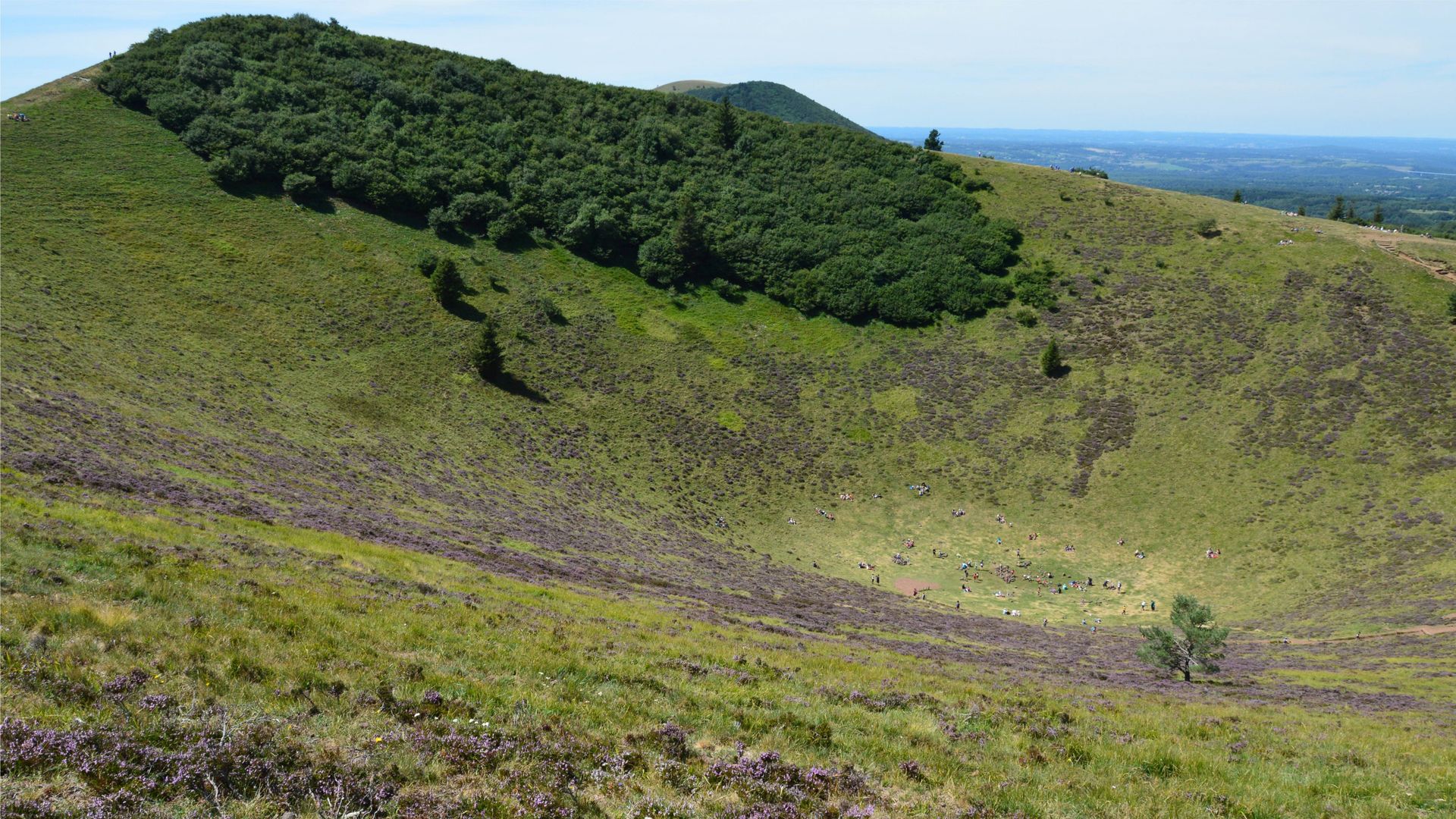 Vue aérienne d'un cratère volcanique verdoyant entouré de végétation