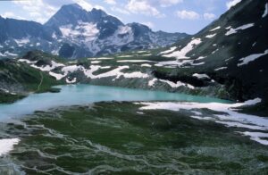 Lac alpin entouré de sommets enneigés à Pralognan-la-Vanoise