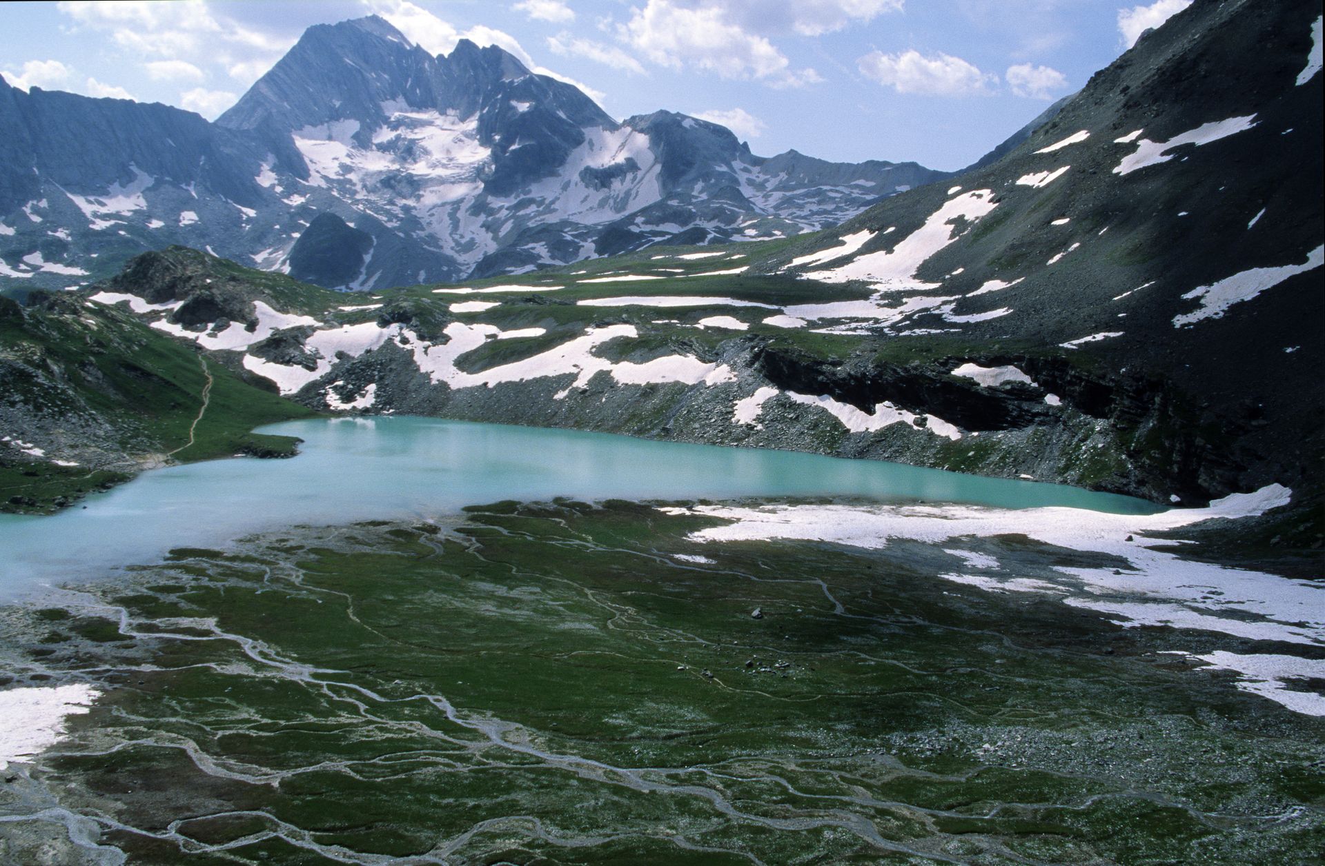 Lac alpin entouré de sommets enneigés à Pralognan-la-Vanoise
