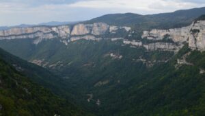 Vallée boisée bordée de falaises calcaires dans le massif du Vercors